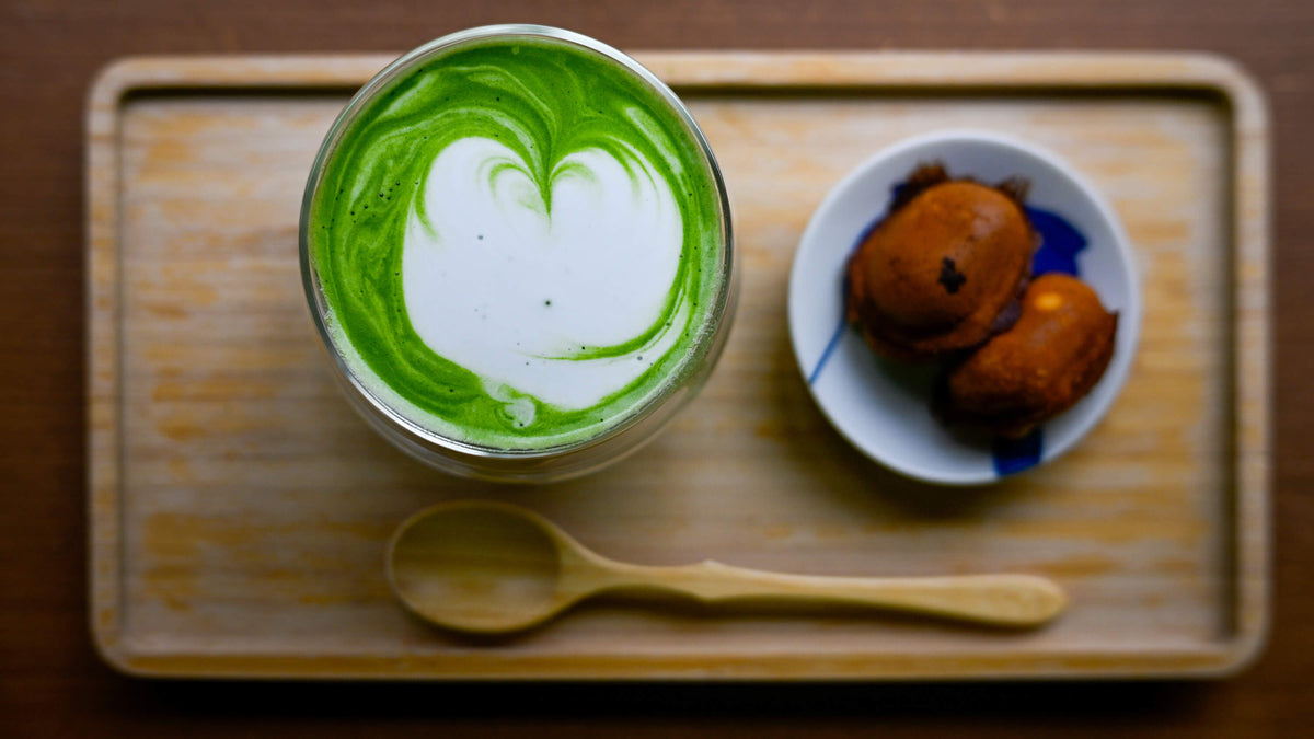 Matcha Latte im Café Totaro in Kyoto, original japanisch, serviert im doppelwandigen Glas auf einem Bambustablett