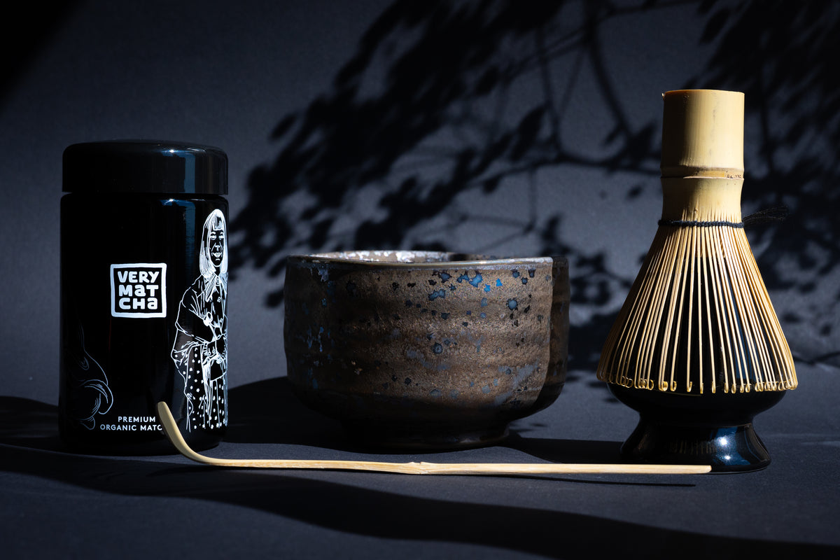 Matcha Set mit Ceremony Bio Matcha von Very Matcha, Matcha-Schale (Chawan), Bambusbesen (Chasen) und Bambsulöffel (Chashaku) auf dunklem Hintergrund