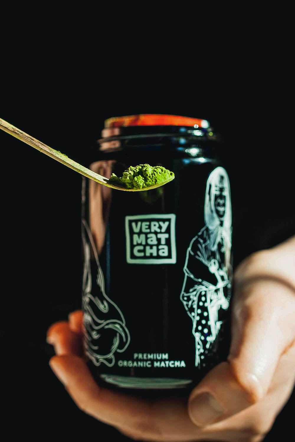 Matcha Dosierung: Bambuslöffel (Chashaku) mit ca. 1 g Matcha-Pulver vor einem Very Matcha Violettglas