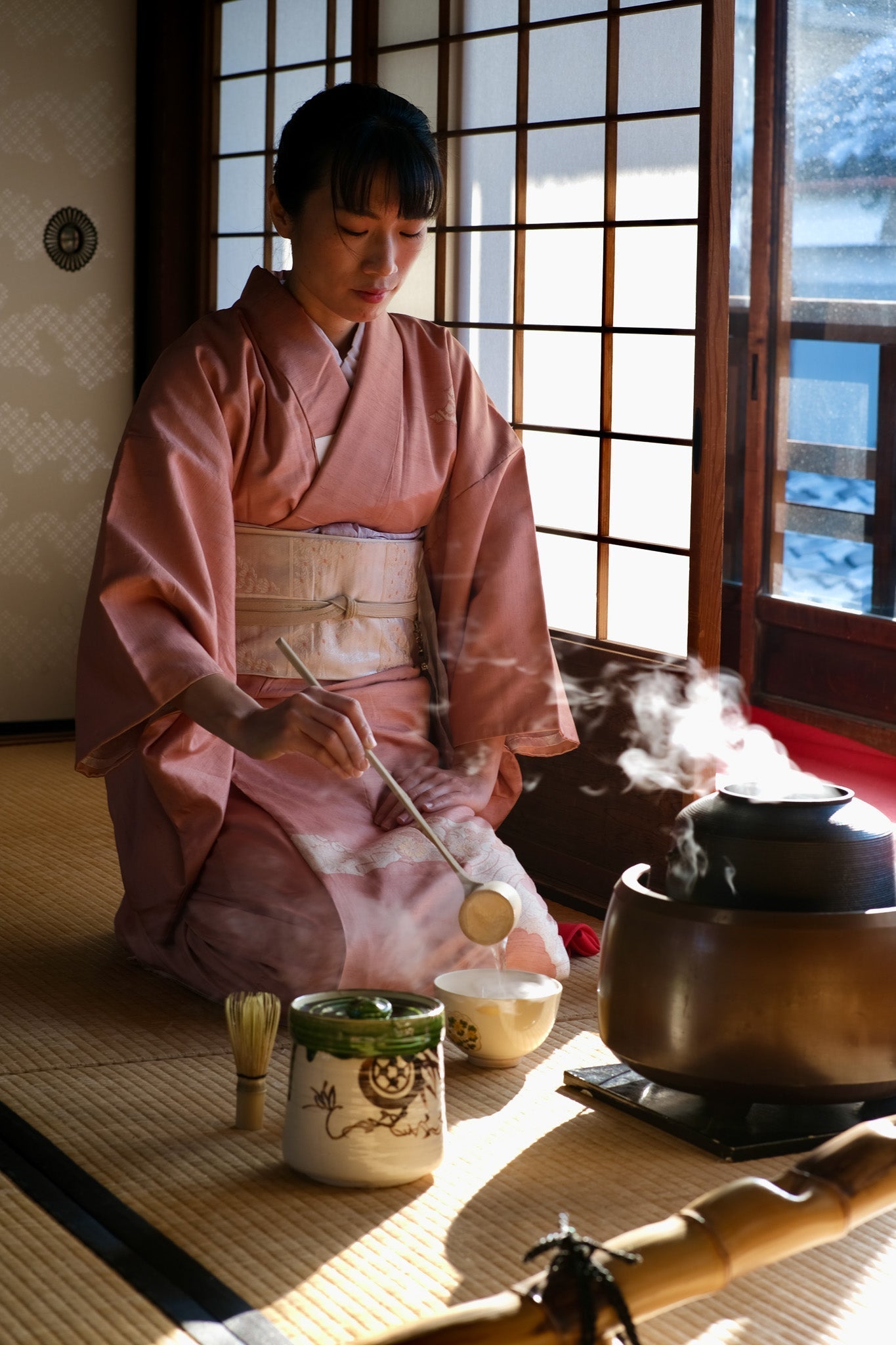 Matcha-Zubereitung in traditioneller Teezeremonie. Sanftes Koffein für Schwangere und Stillende mit Bambusbesen und Keramikschale.