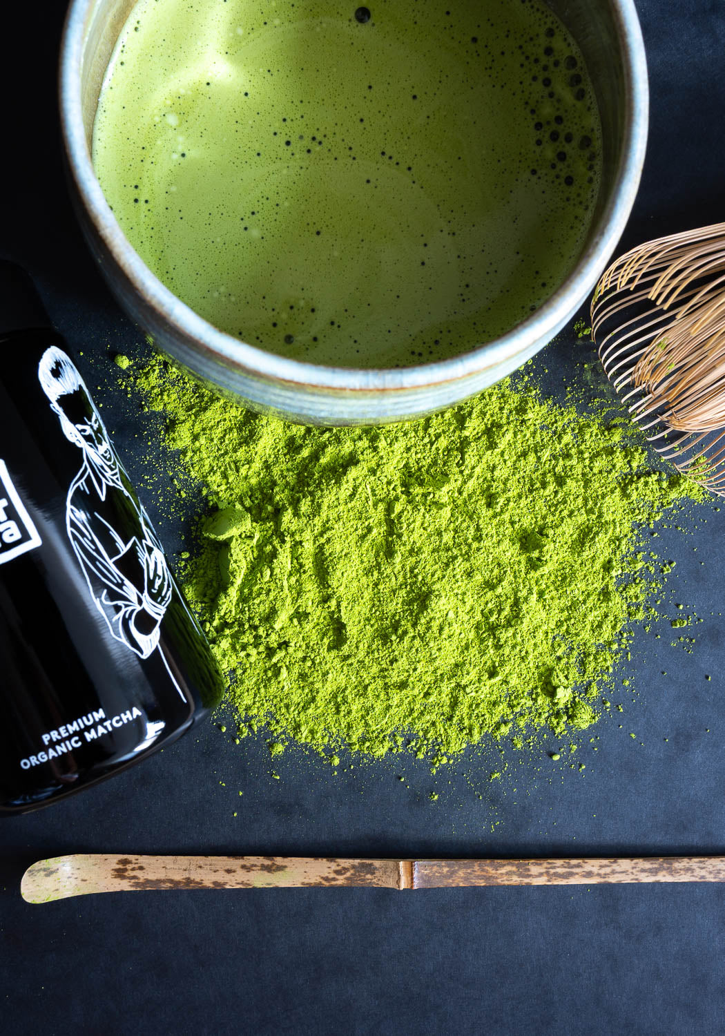 Matcha-Set mit Matcha-Schale, Matcha-Besen und Matcha-Löffel neben Very Matcha Premium Organic Matcha-Pulver auf schwarzem Untergrund
