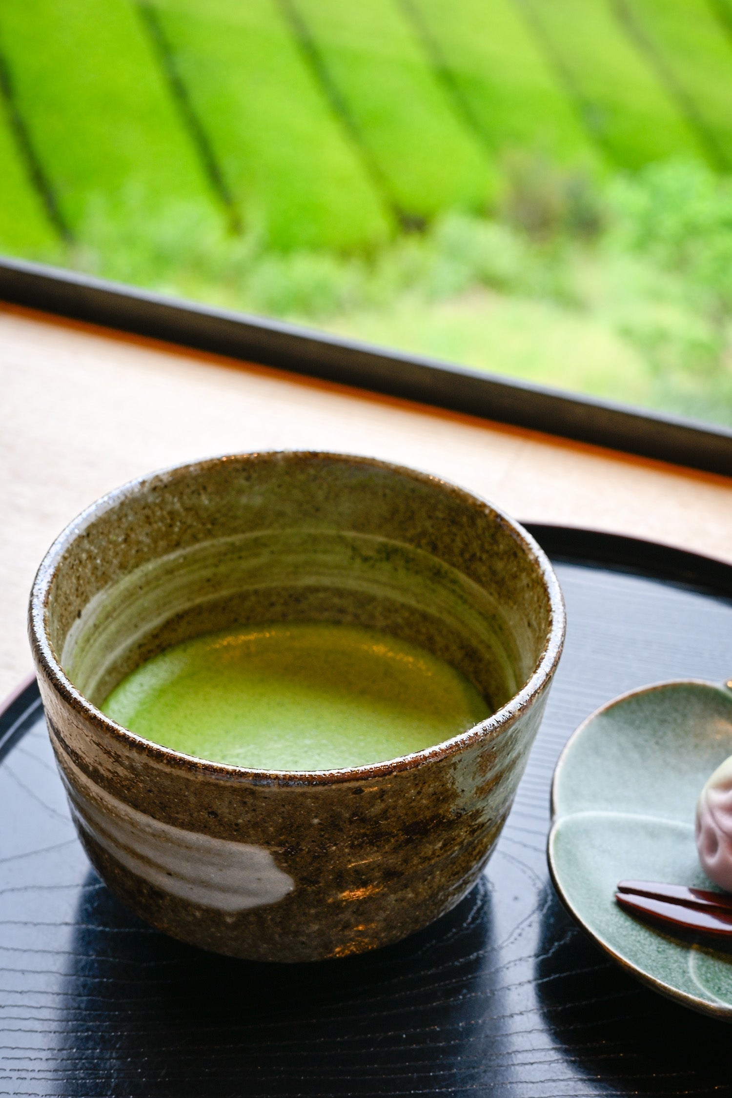 Ein Umami-reicher Ceremonial Grade Matcha in einem Café in Uji, Wazuka, Japan mit Teefeldern im Hintergrund.