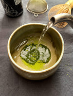 Matcha mit Wasser verrühren