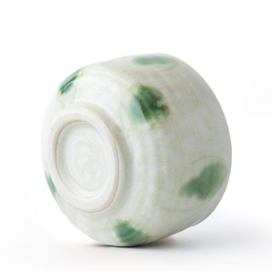 Detailansicht der Mizutama-Oribe-Glasur der Matcha-Schale AOBA mit grünen, unregelmäßigen Punkten auf heller Keramik