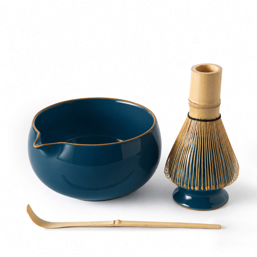 Matcha Set YORU in dunklem Blaugrün mit Matcha Schale, Bambusbesen Chasen, Bambuslöffel Chashaku und Keramik Besenhalter aus leicht erhöhter Perspektive auf weißem Hintergrund.